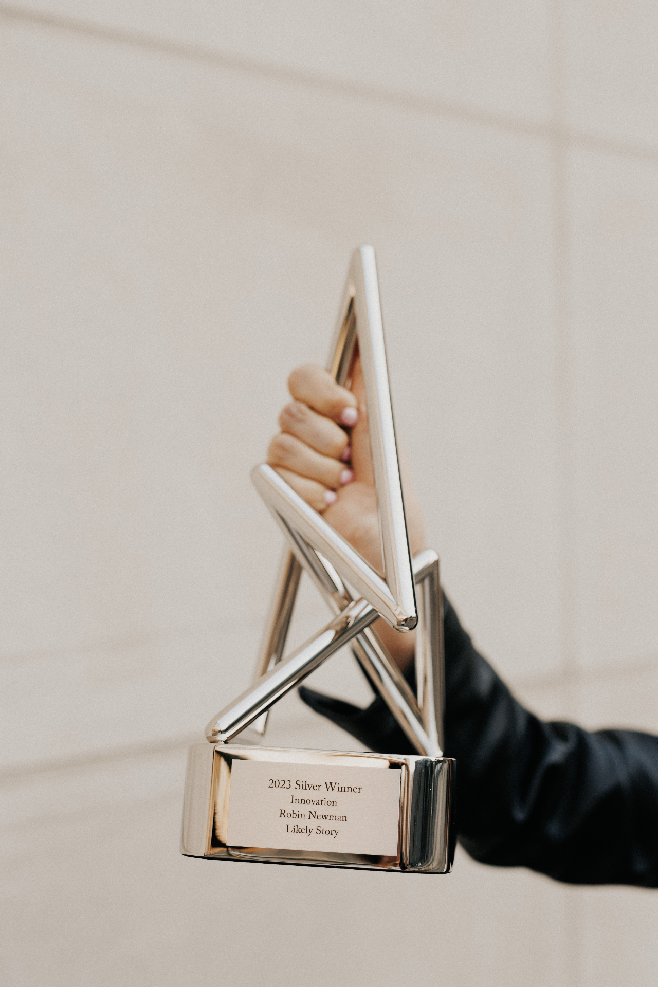 Robin Newman holding a 2023 Silver Anthem Award for Innovation for Likely Story.
